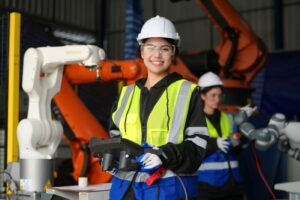 O que é indústria 4.0​: engenheira manuseando equipamento moderno com controle remoto na indústria.