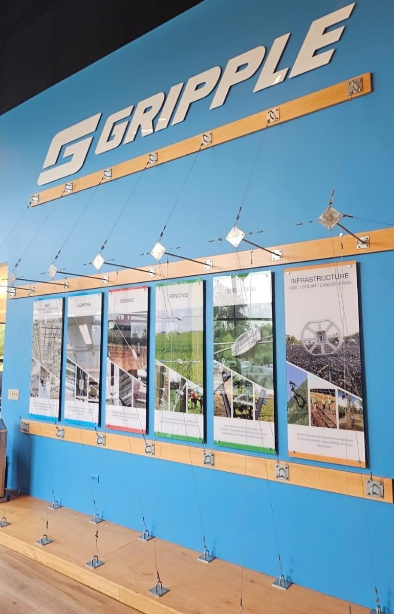 Painel da marca Gripple com sistemas de suspensão por cabos de aço em exposição