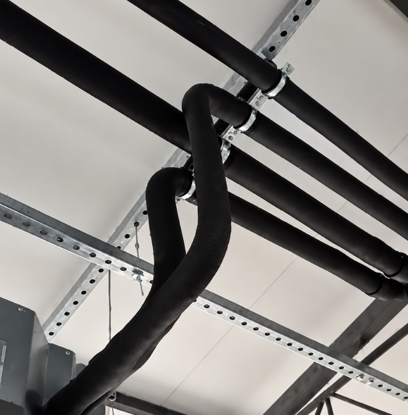 Instalação de climatização com tubulação isolada fixada em suportes modulares tipo trapézio